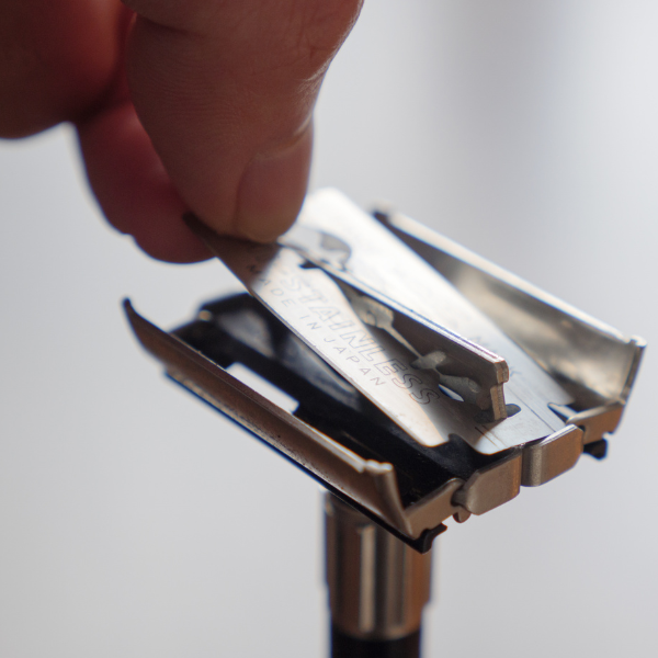 A man changing the razor blade on a double edged safety razor